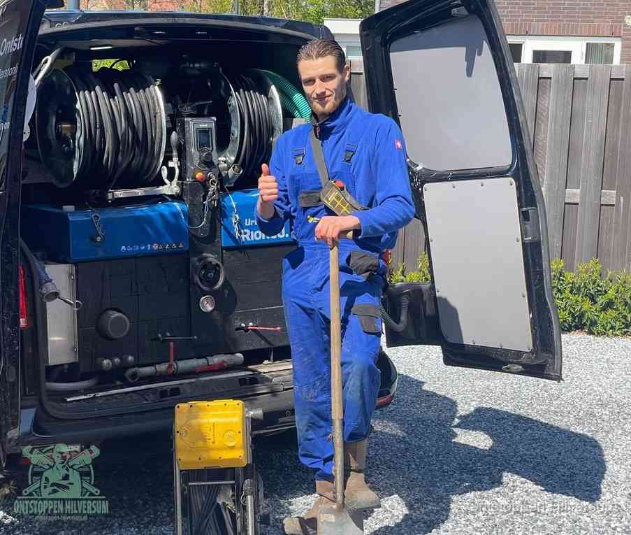 Een tevreden monteur met opgestoken duim naast de bestelbus, slim ingrijpen bespaart kosten bij een verstopte afvoer in Hilversum