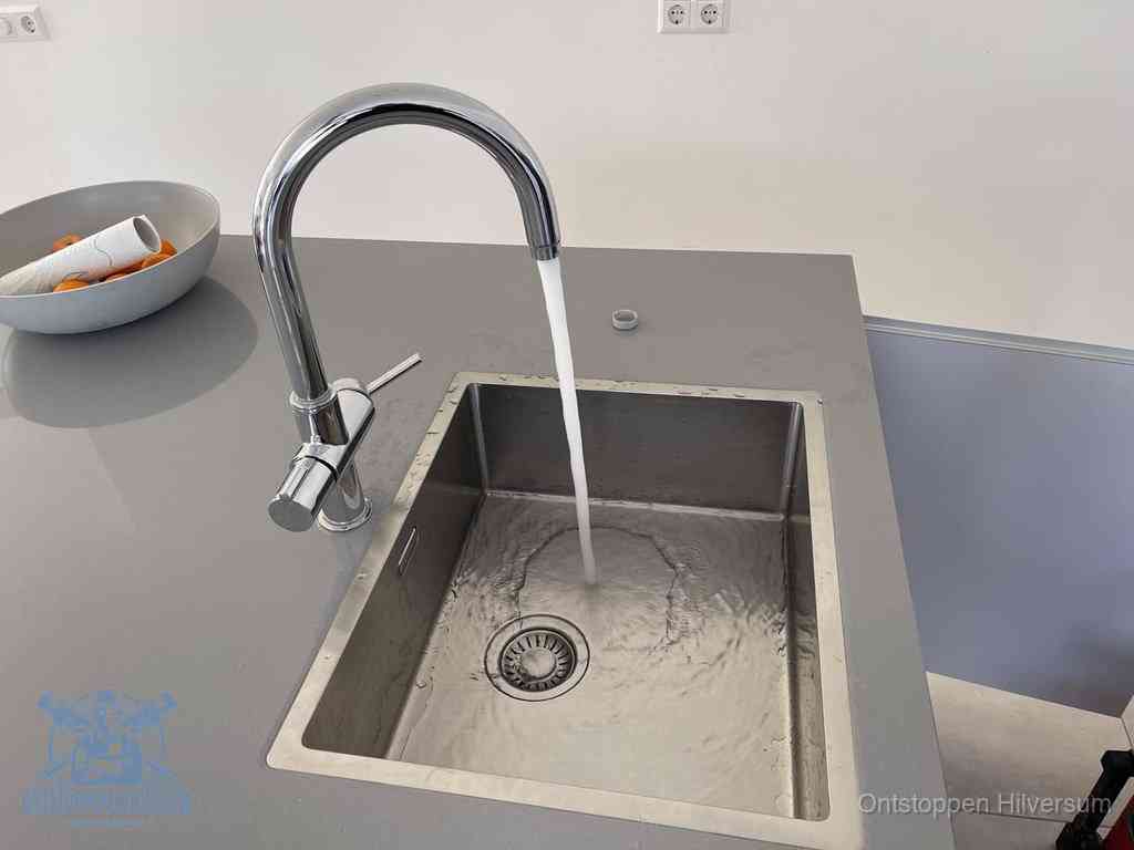 Een vrij doorstromende rvs spoelbak waar het water moeiteloos wegloopt, het resultaat van slim onderhoud dat geld bespaart in Hilversum