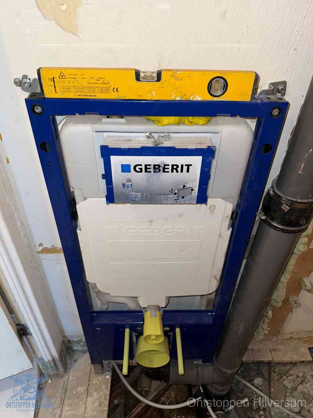 Een Geberit inbouwreservoir met frame voor een hangtoilet tegen de wand, met de afvoerbocht naar de vloer, kenmerkend voor een verstopt hangtoilet in Hilversum