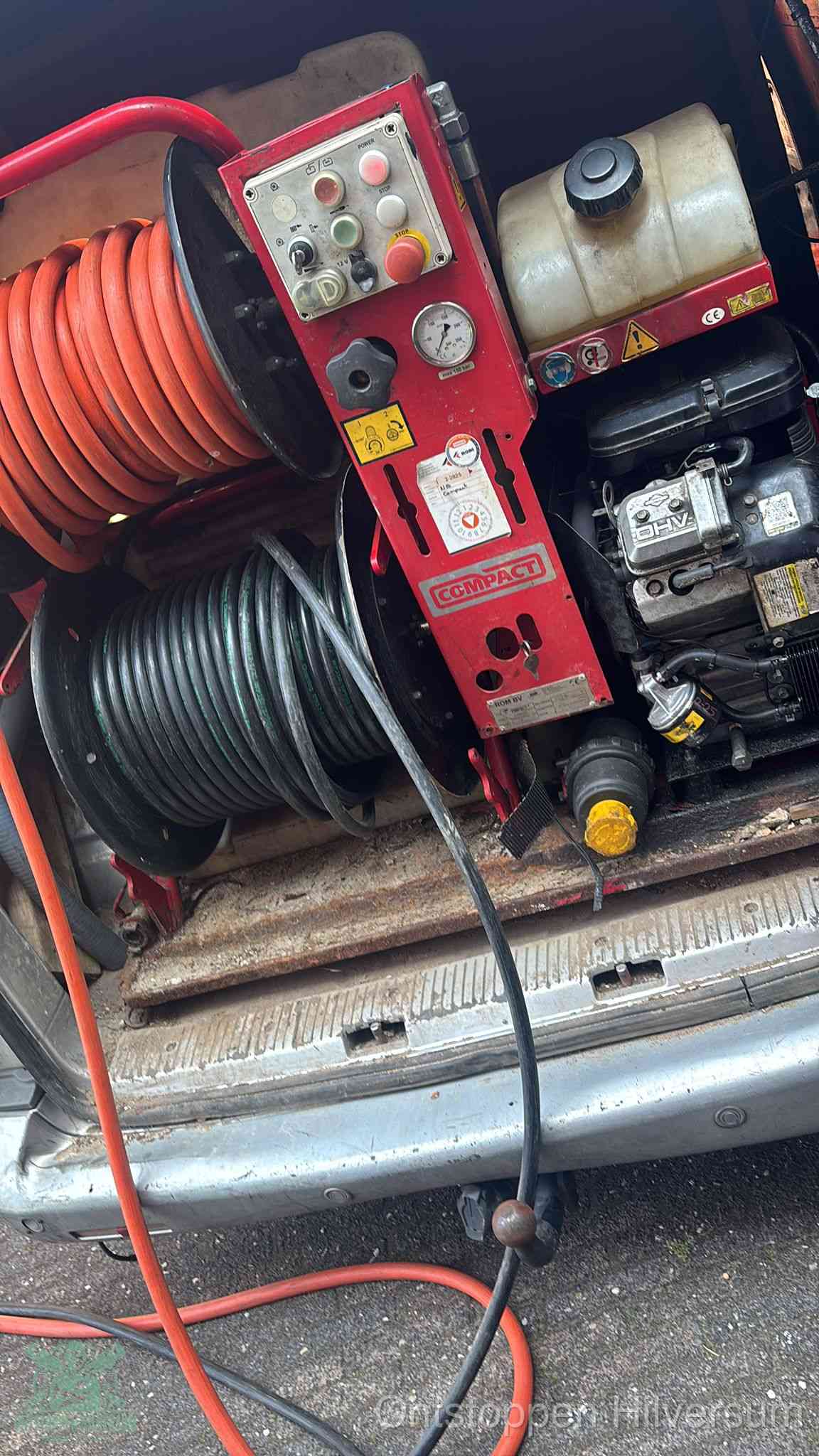 Een rood hogedruk-rioolreinigingstoestel in de laadbak van de bedrijfsbus, apparatuur voor een hardnekkige afvoerverstopping in Hilversum