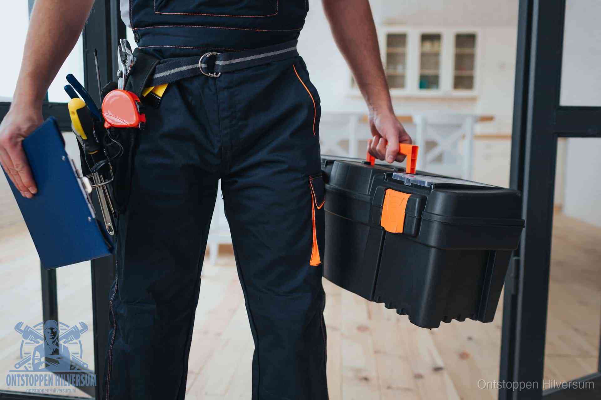 Een monteur met gereedschapsriem en klembord in een keuken, klaar om een transparante prijs voor het gootsteen ontstoppen in Hilversum te geven