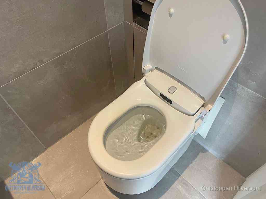 Een toiletpot vol troebel water met drijvend papier en restanten, de meest voorkomende oorzaak van een verstopte wc in Hilversum