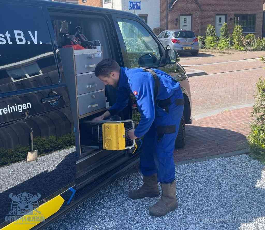 Een monteur pakt apparatuur uit de bedrijfsbus voor service aan huis, het moment om een professional in te schakelen in Hilversum