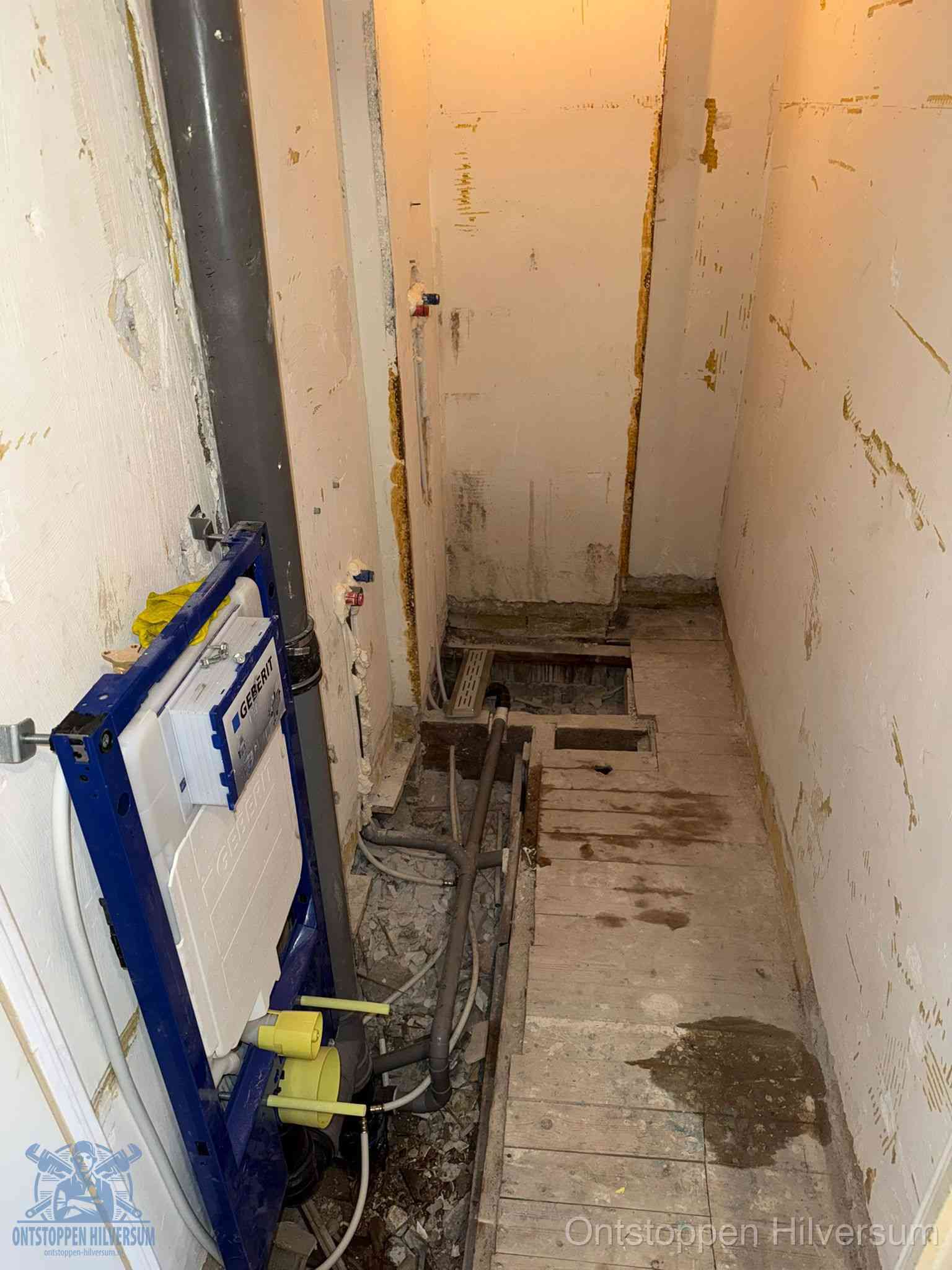 Een opgebroken toiletruimte tijdens renovatie met een Geberit inbouwreservoir en blootliggende oude afvoerleidingen, typisch voor oudere woningen in Hilversum